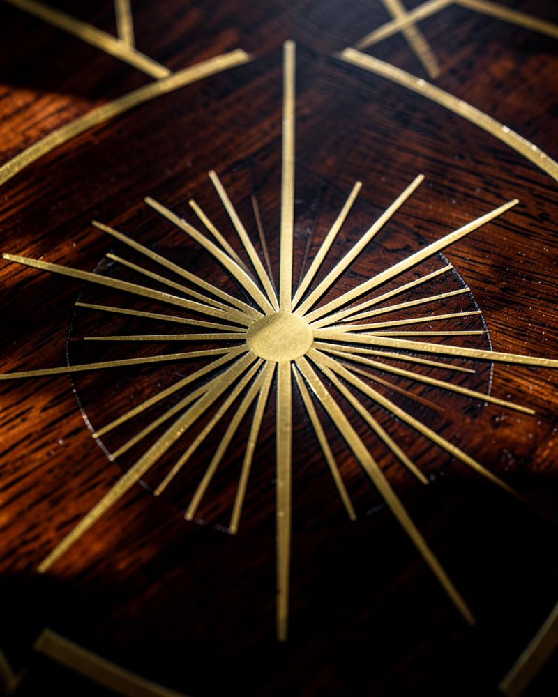 Brass sunburst inlay on walnut
